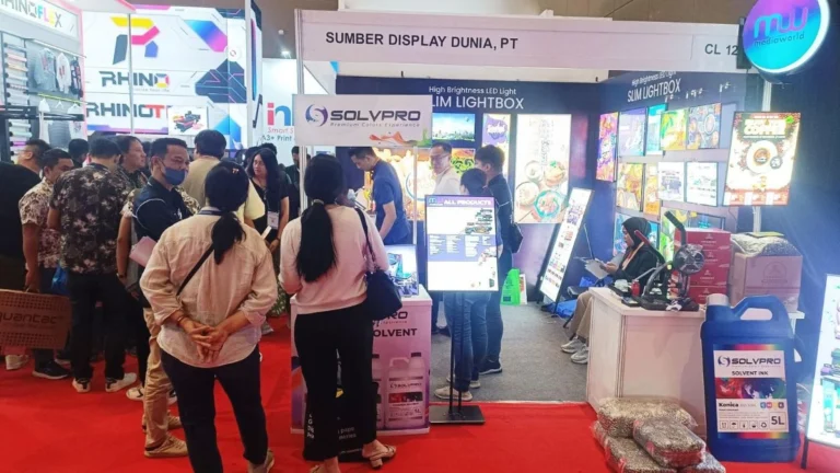 Operator memeriksa hasil cetak banner di ruang produksi sebagai proses QC supplier digital printing.